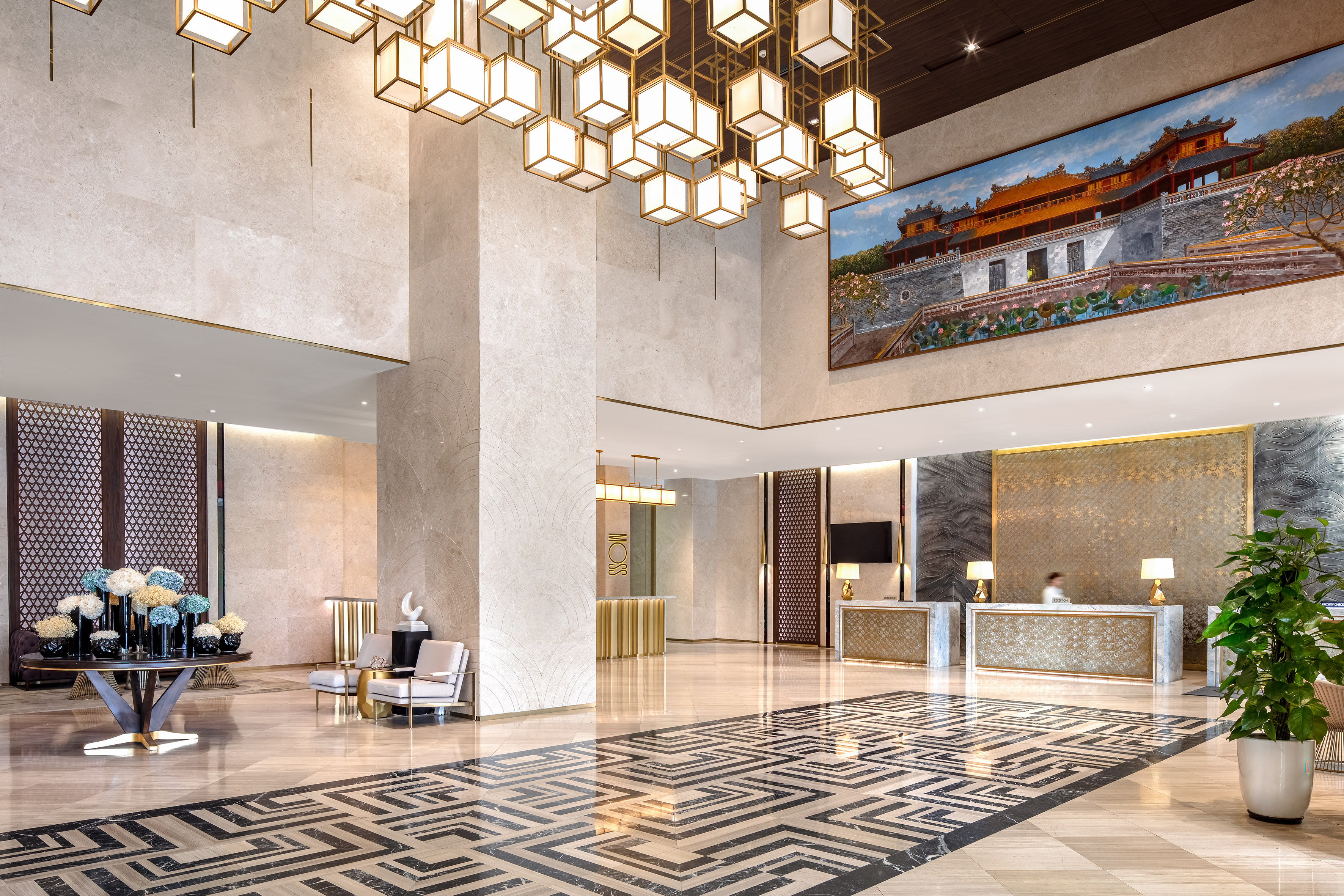 Luxurious hotel lobby with grand chandelier, marble floor, and reception area.