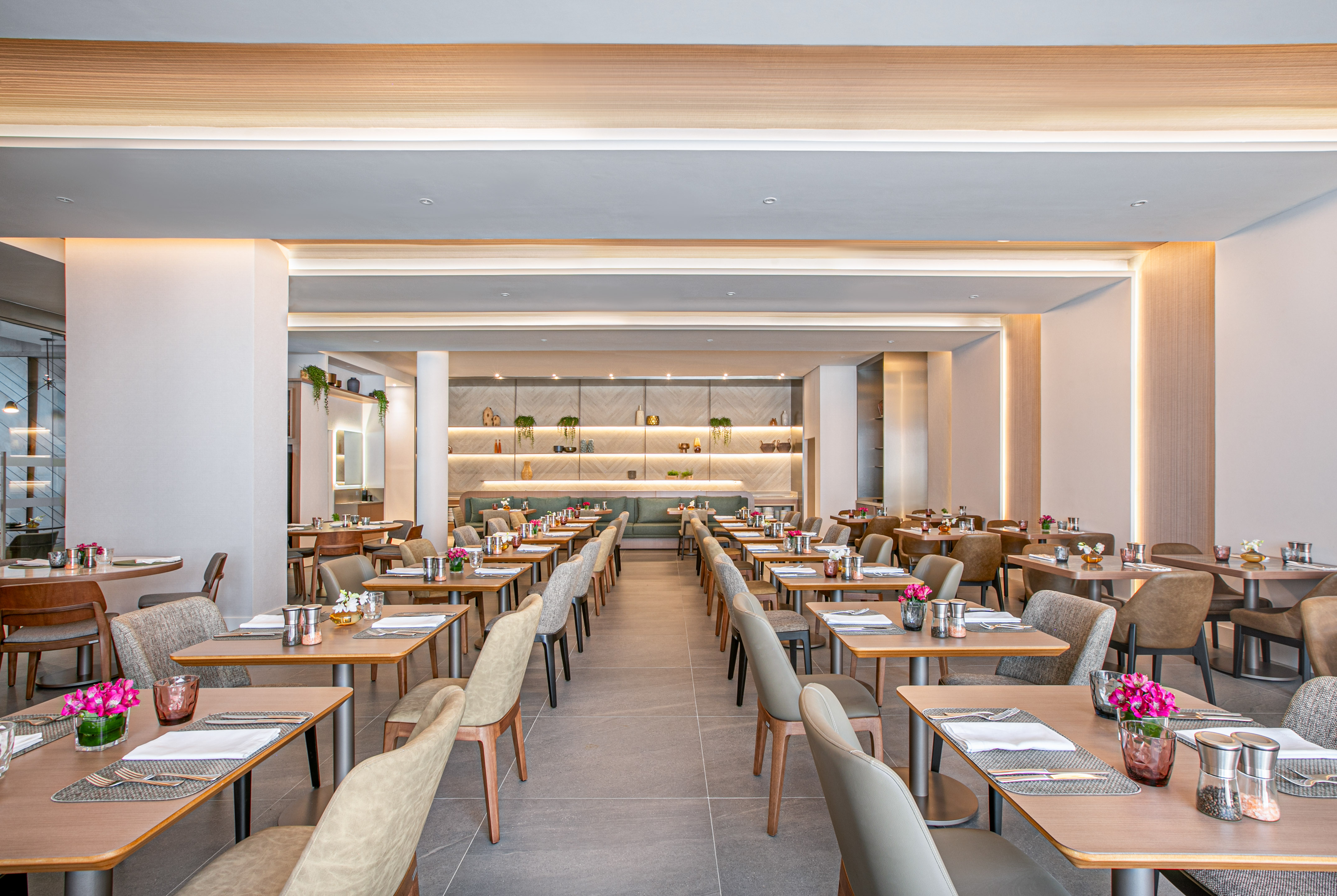 Modern restaurant dining room with set tables and contemporary decor.