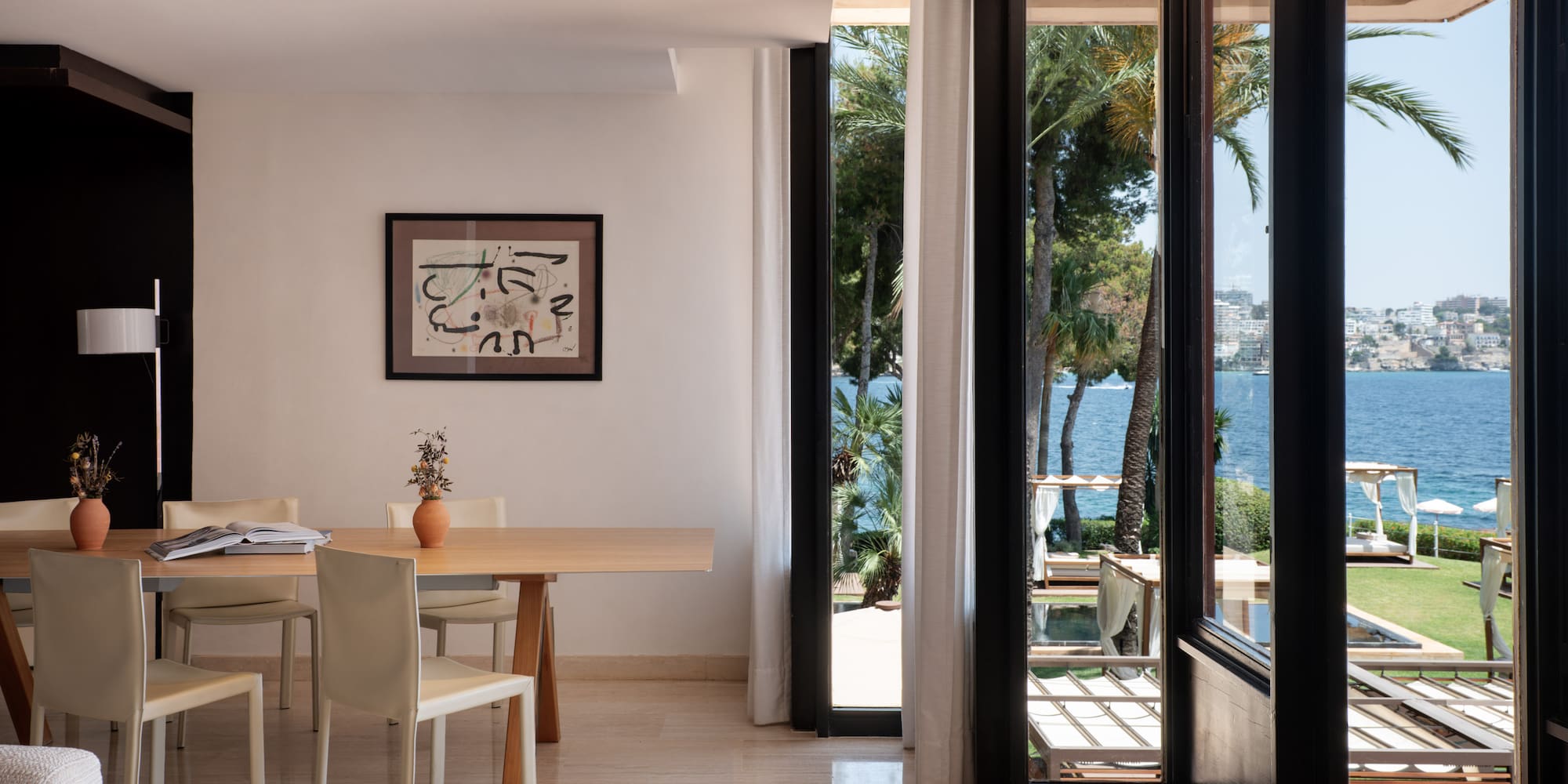 a room with a table and chairs and a view of the water