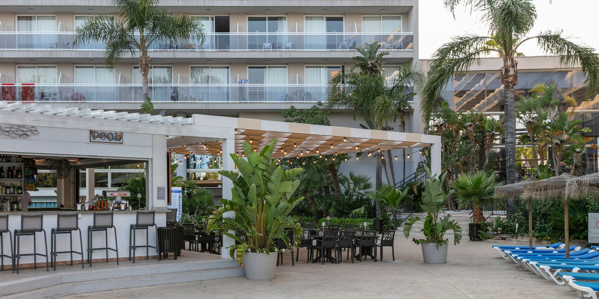 a patio area with chairs and tables in front of a building