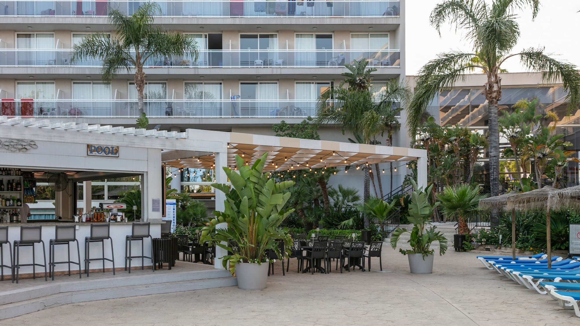 a patio area with chairs and tables in front of a building
