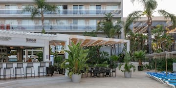a patio area with chairs and tables in front of a building