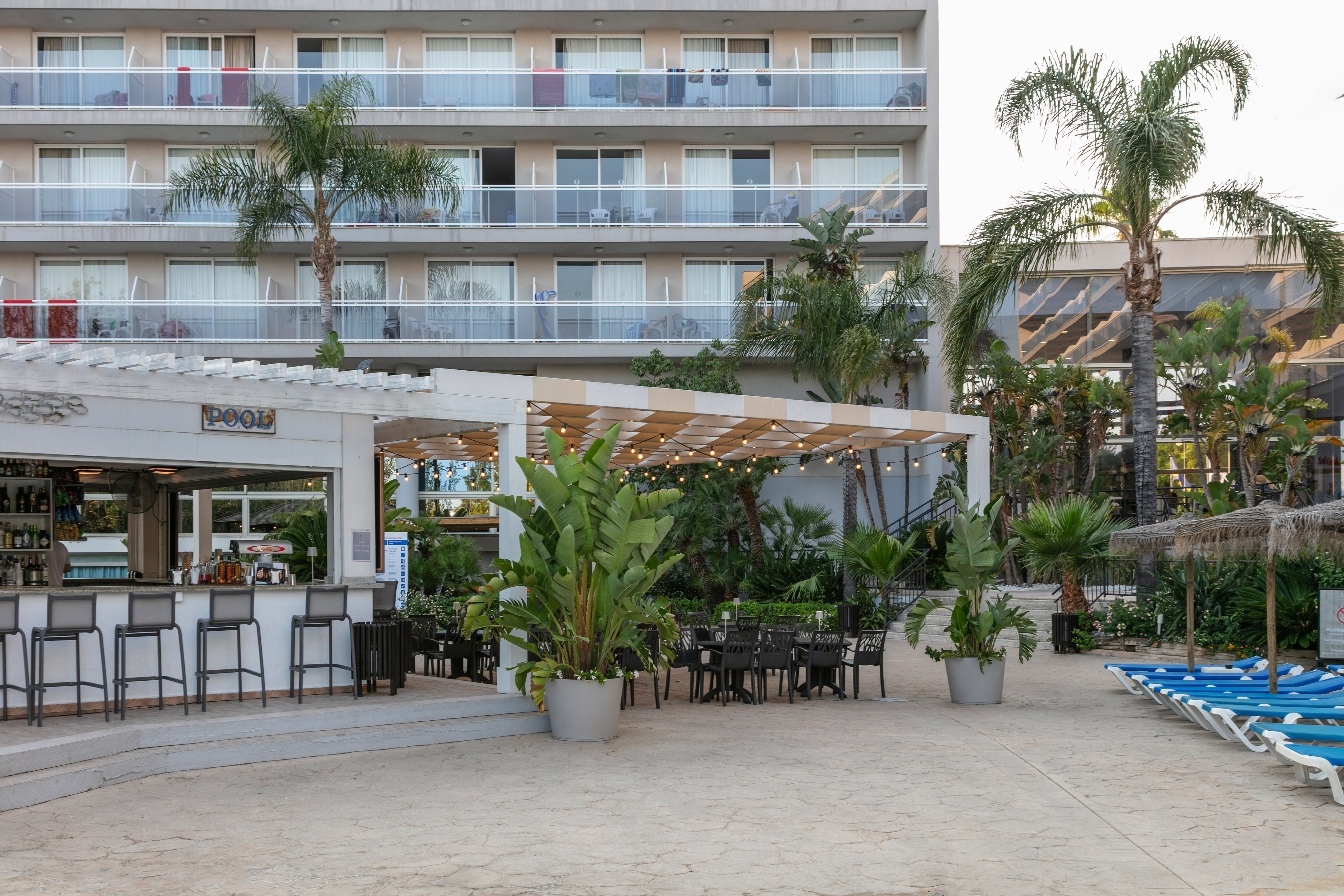 a patio area with chairs and tables in front of a building
