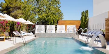 a pool with water jets and umbrellas