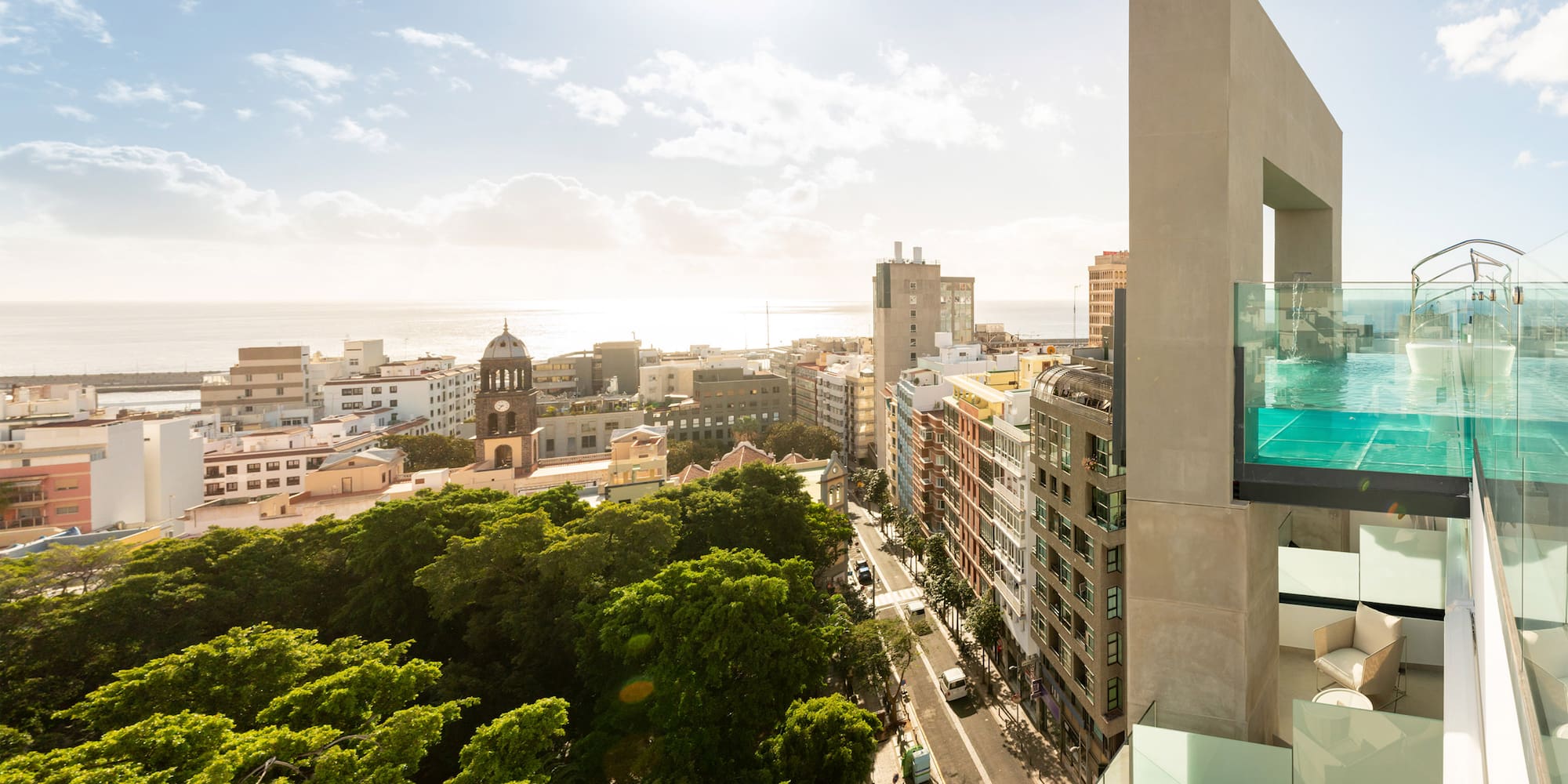 a building with a glass balcony and trees in the background