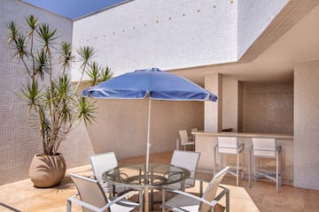 a patio with a table and chairs and a blue umbrella