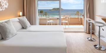 a room with two beds and a view of the ocean