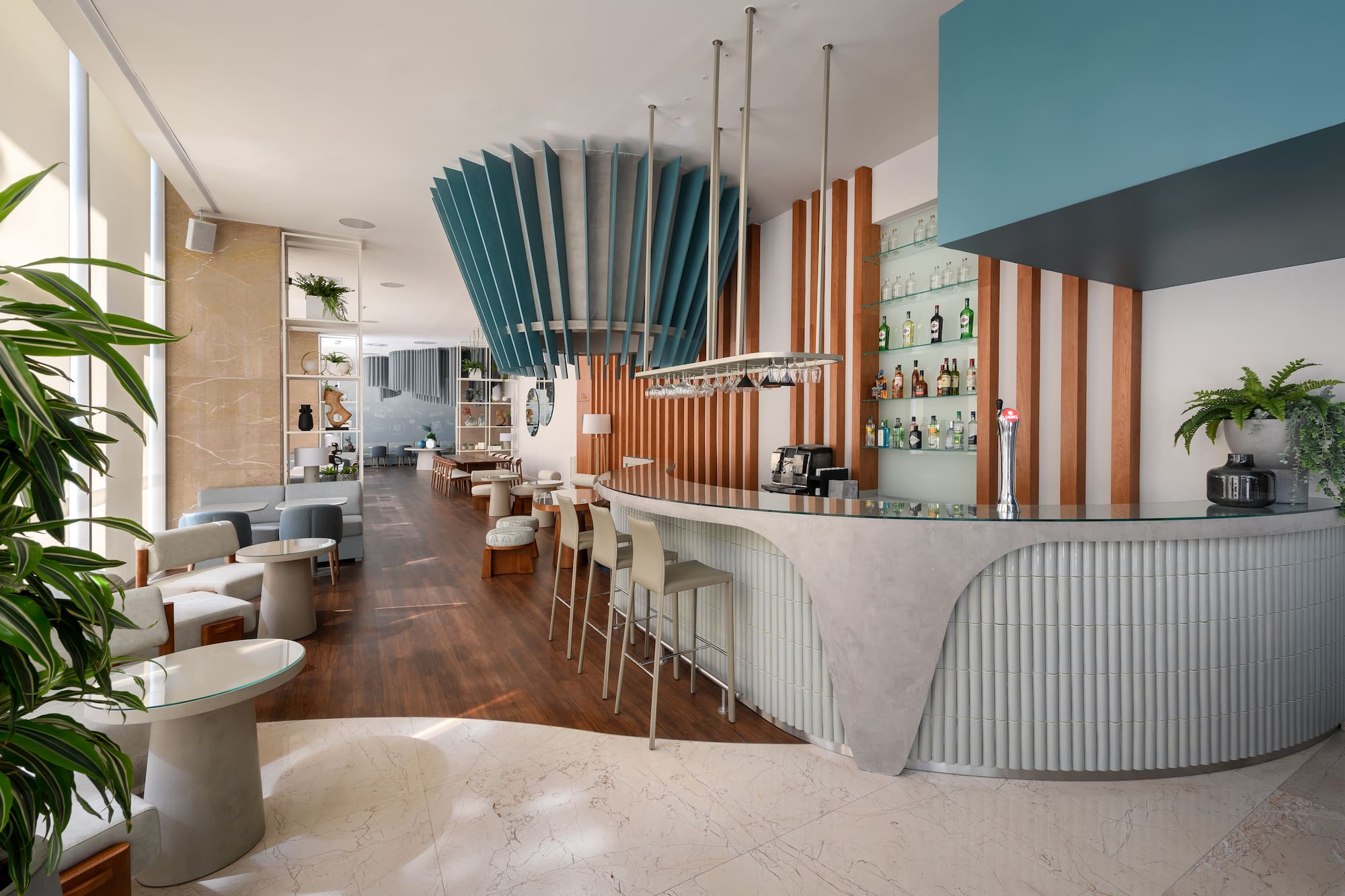 Modern hotel bar with stylish blue acoustic ceiling panels and seating lounge.
