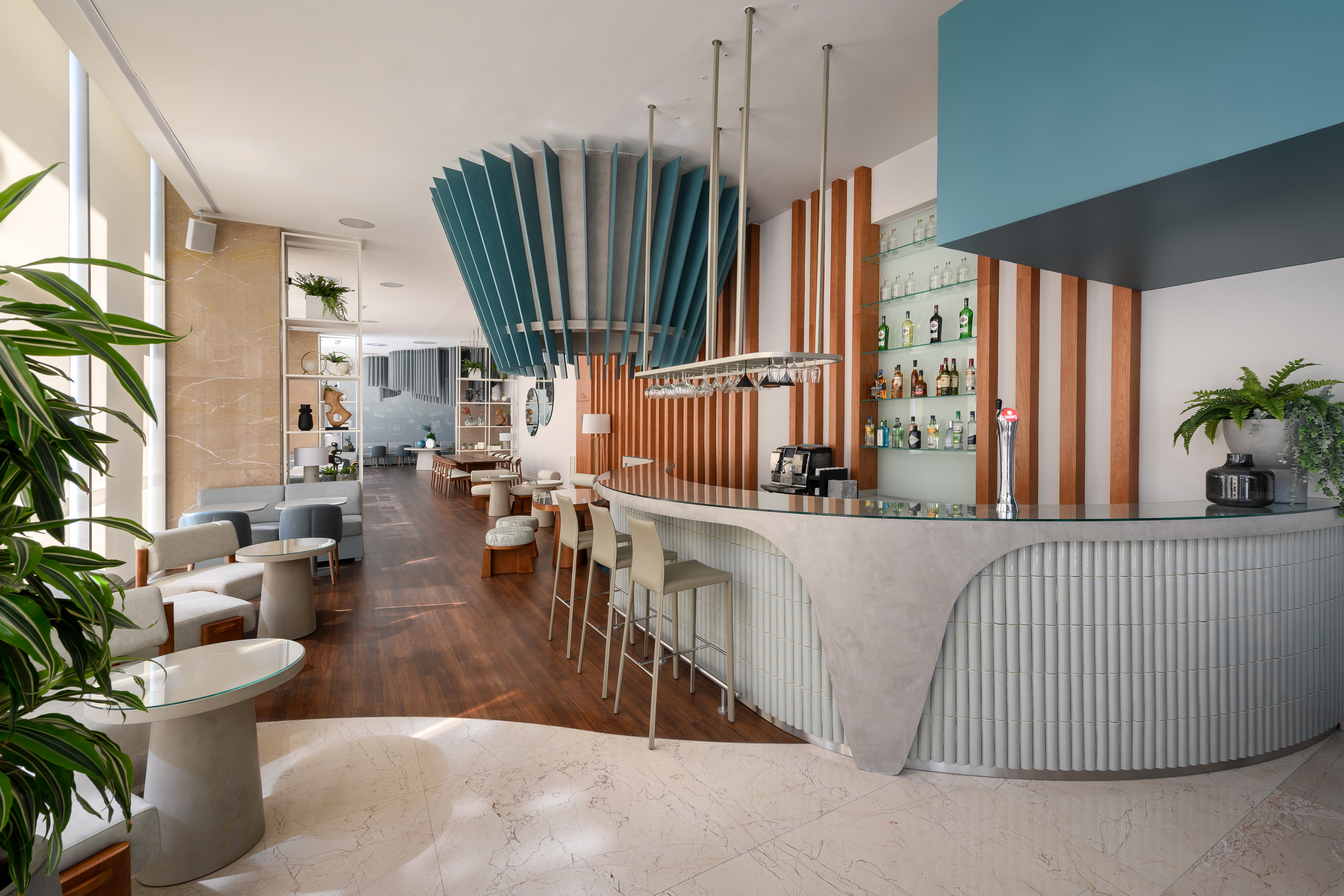 Modern hotel bar with stylish blue acoustic ceiling panels and seating lounge.