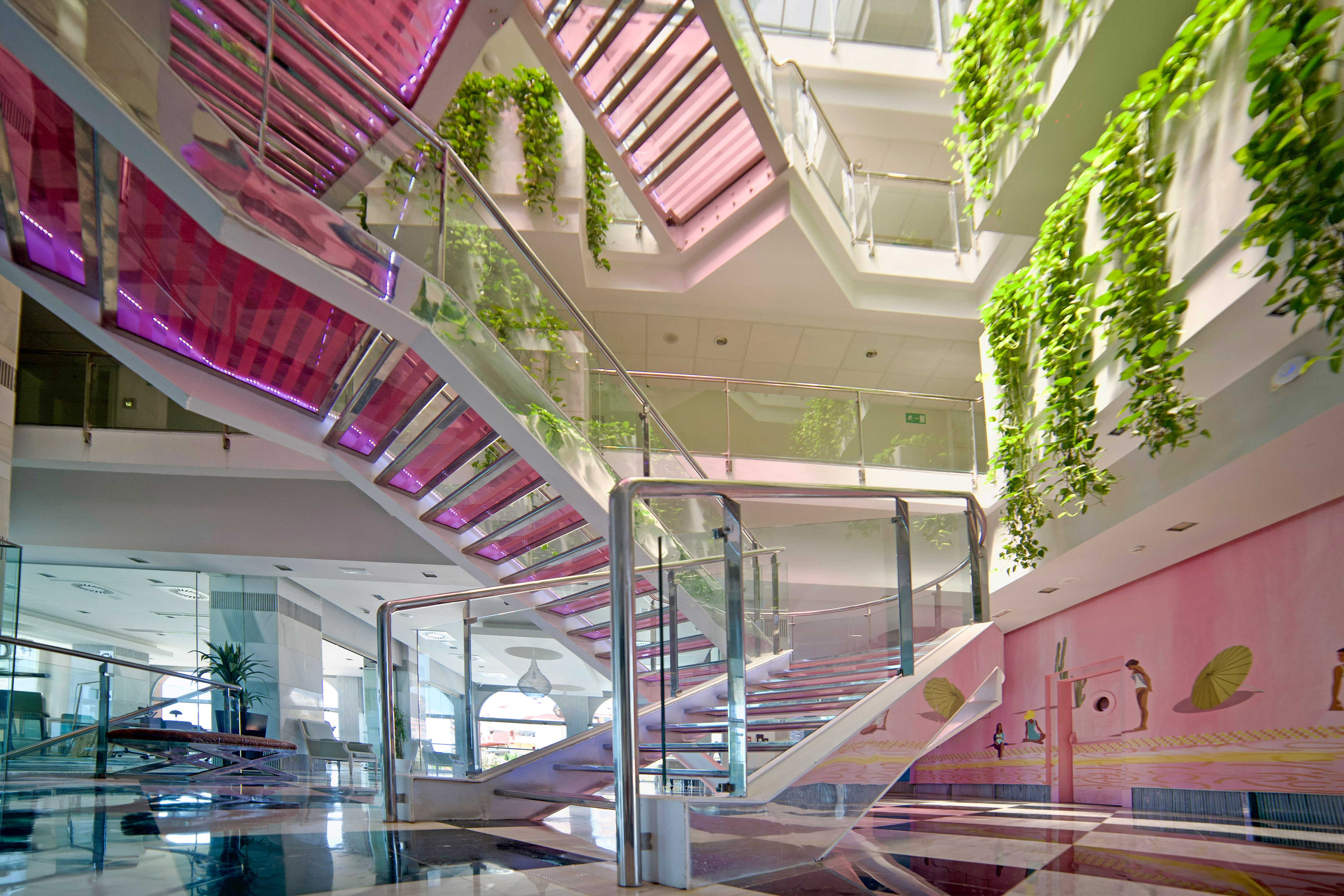 a staircase with glass railings and plants