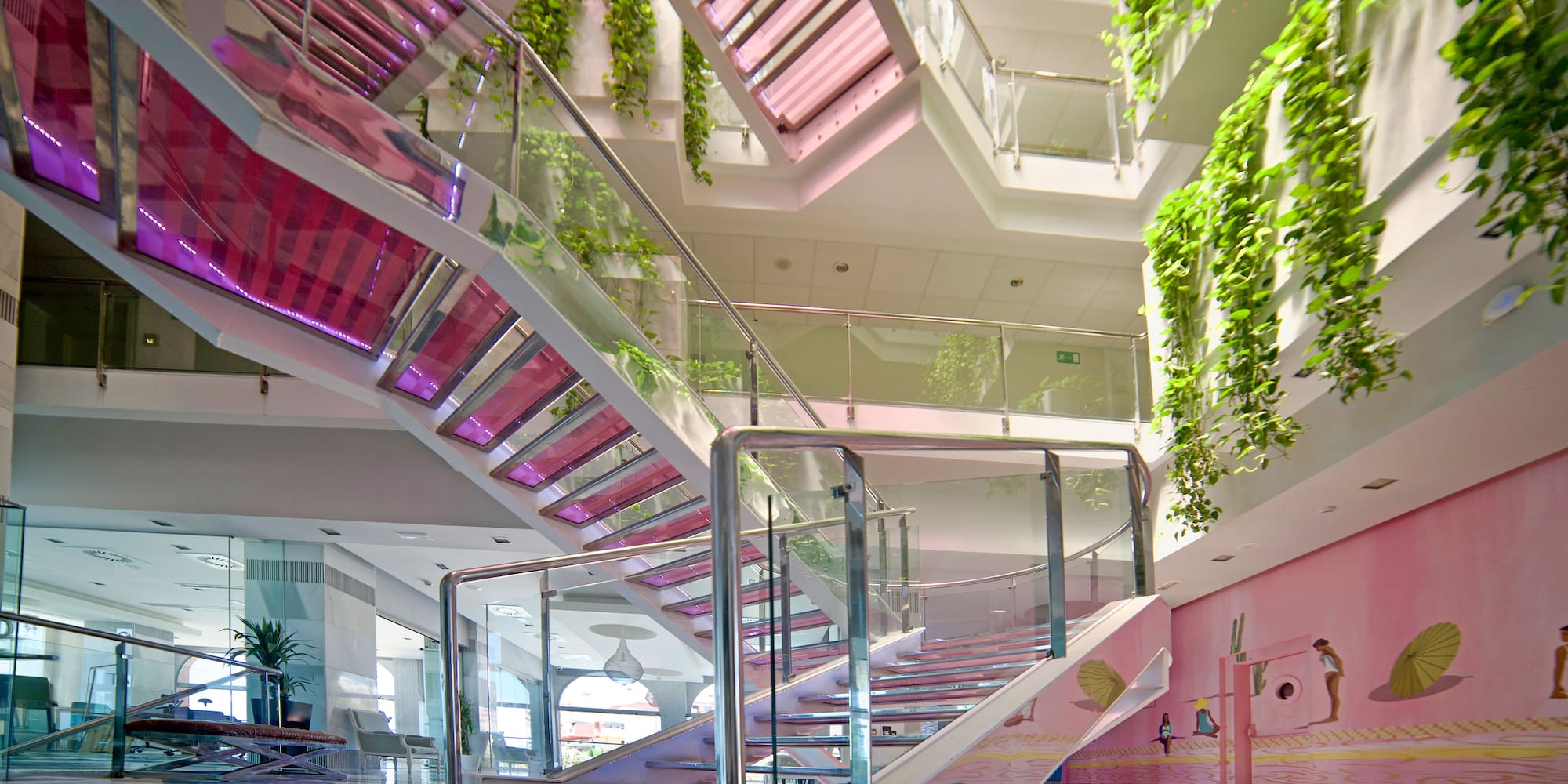 a staircase with glass railings and plants