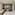 Suite moderna con vista urbana, escritorio rojo, cama y chaise longue.