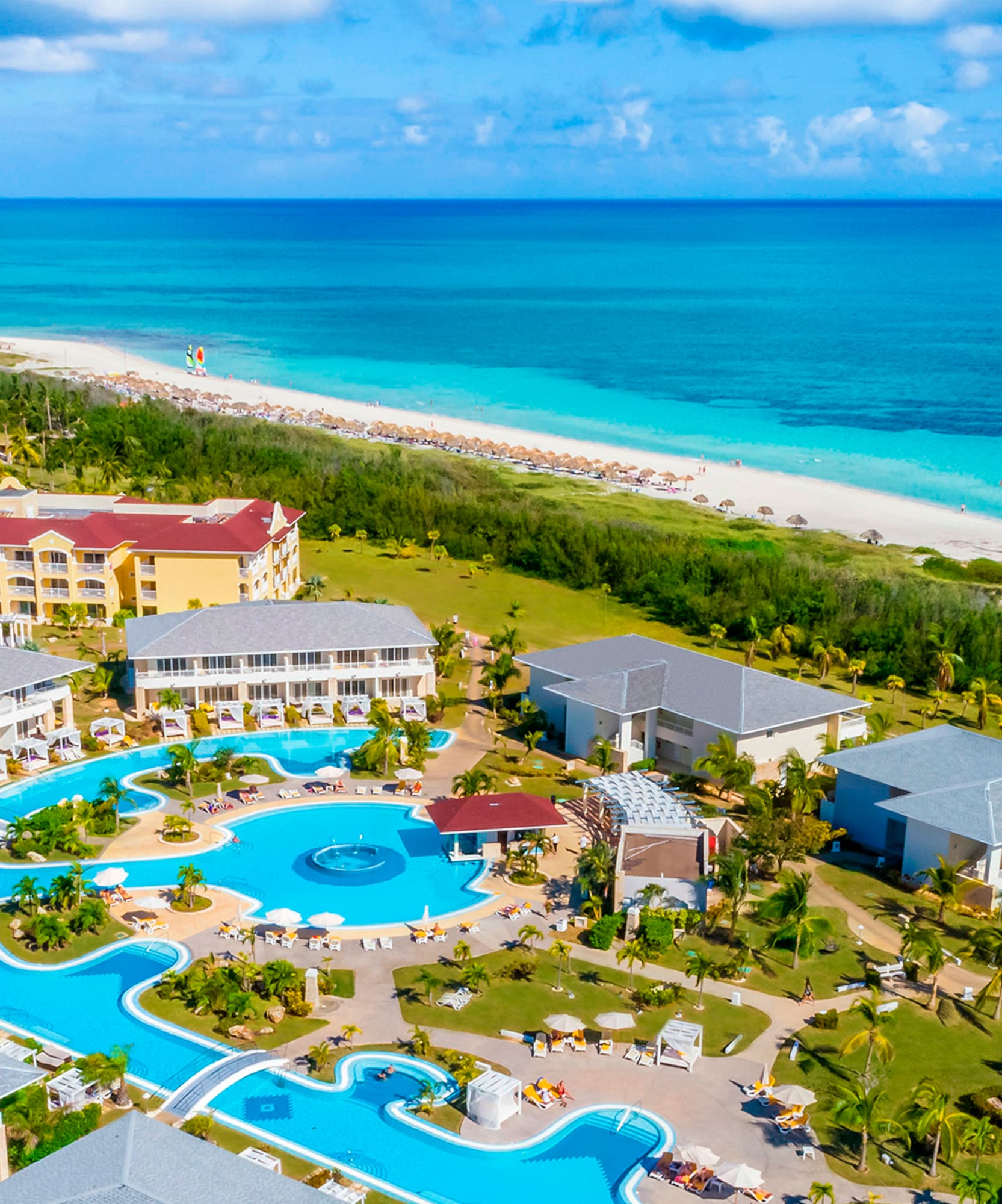 a swimming pool and buildings by a beach