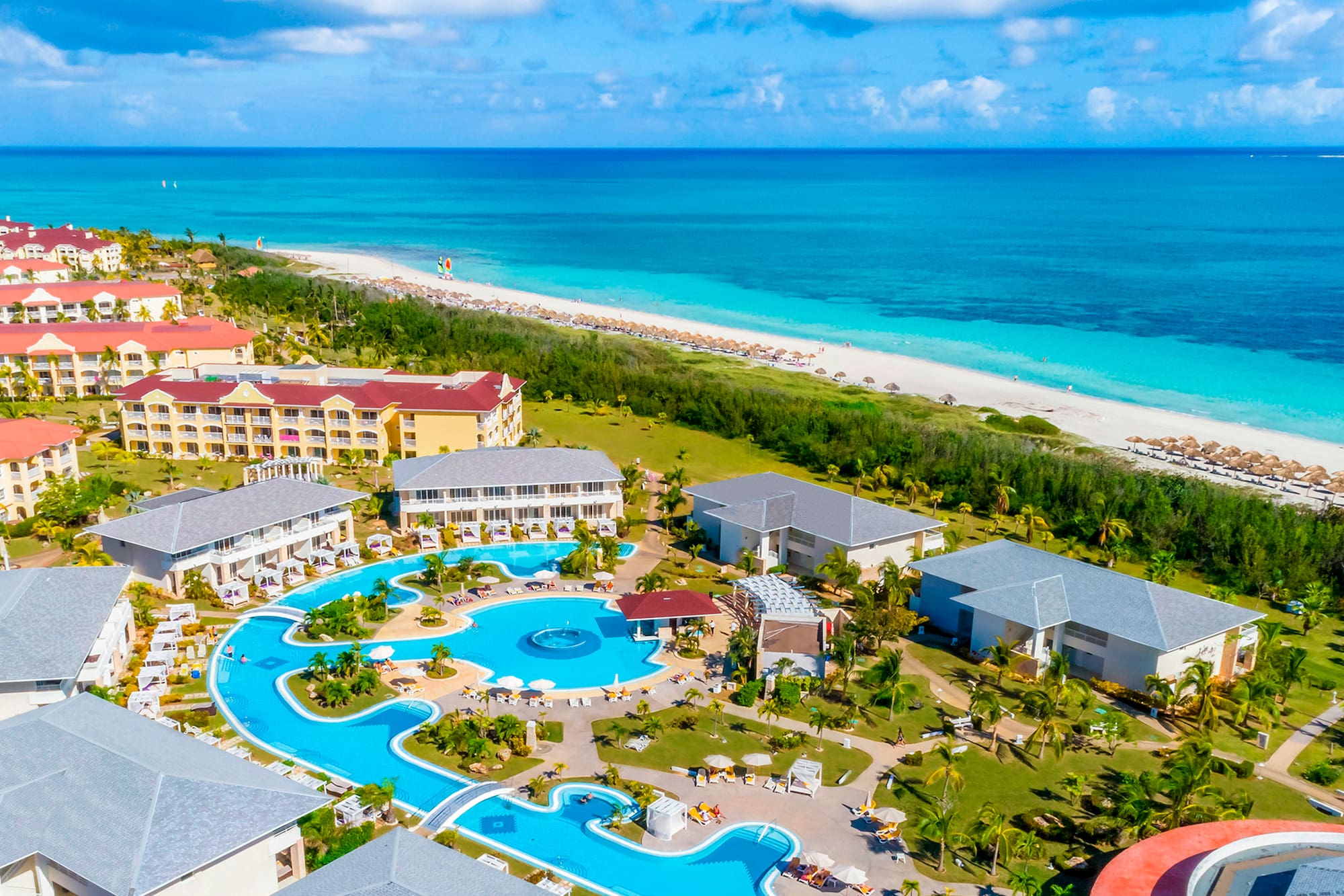 a swimming pool and buildings by a beach