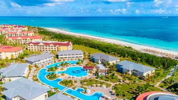 a swimming pool and buildings by a beach