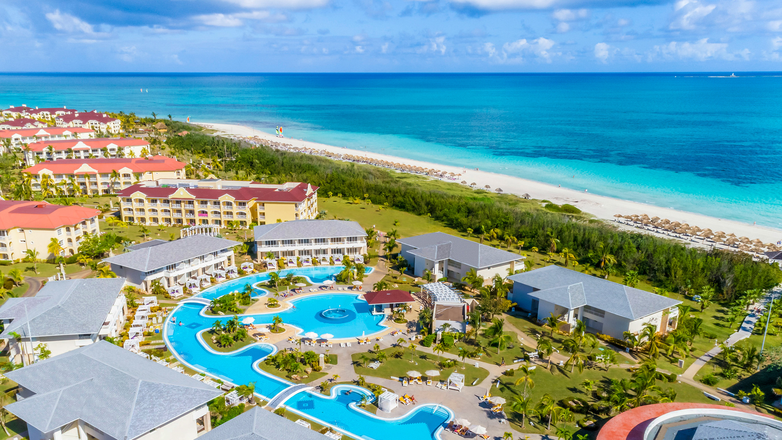 a swimming pool and buildings by a beach