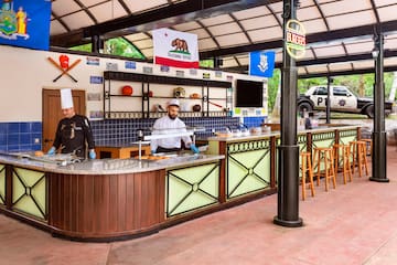 two men in chefs hats behind a counter