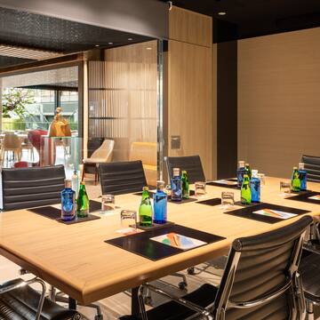 a conference room with a table with chairs and bottles of water