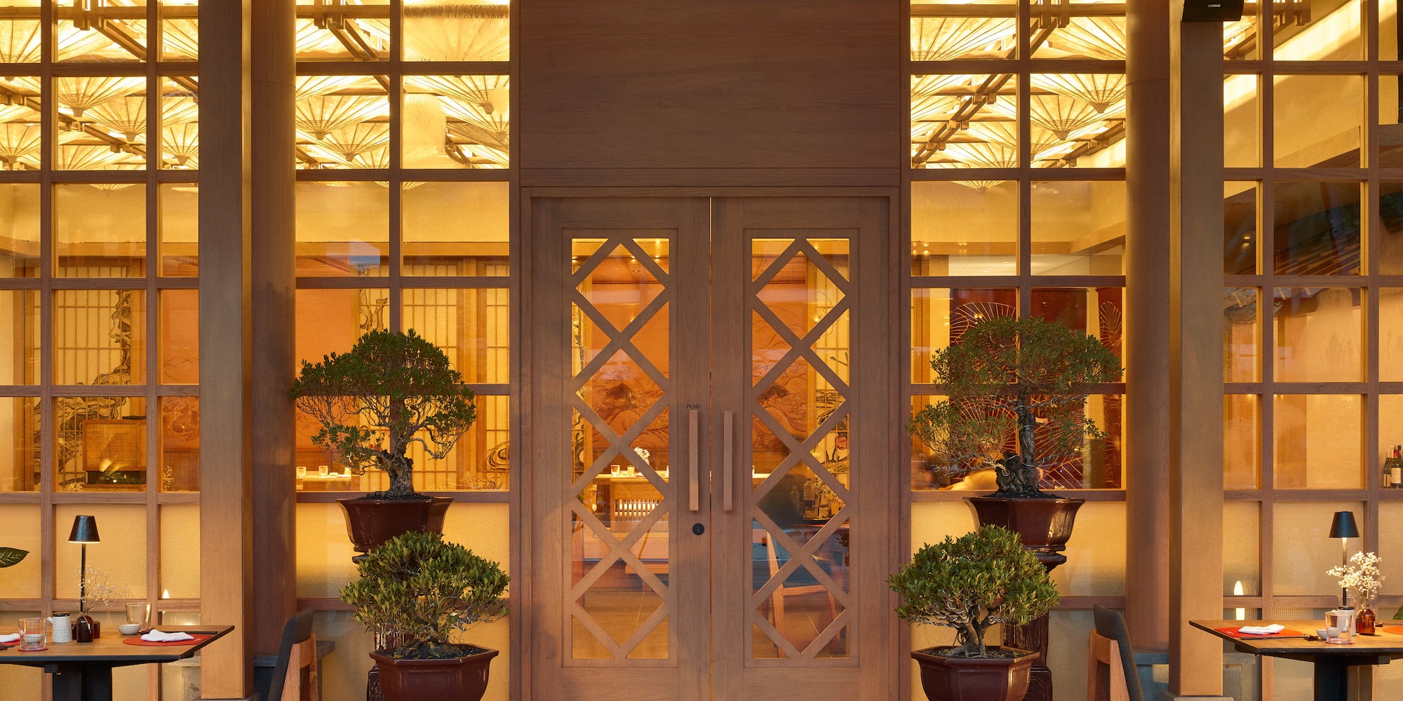 a front door of a building with a couple of potted trees