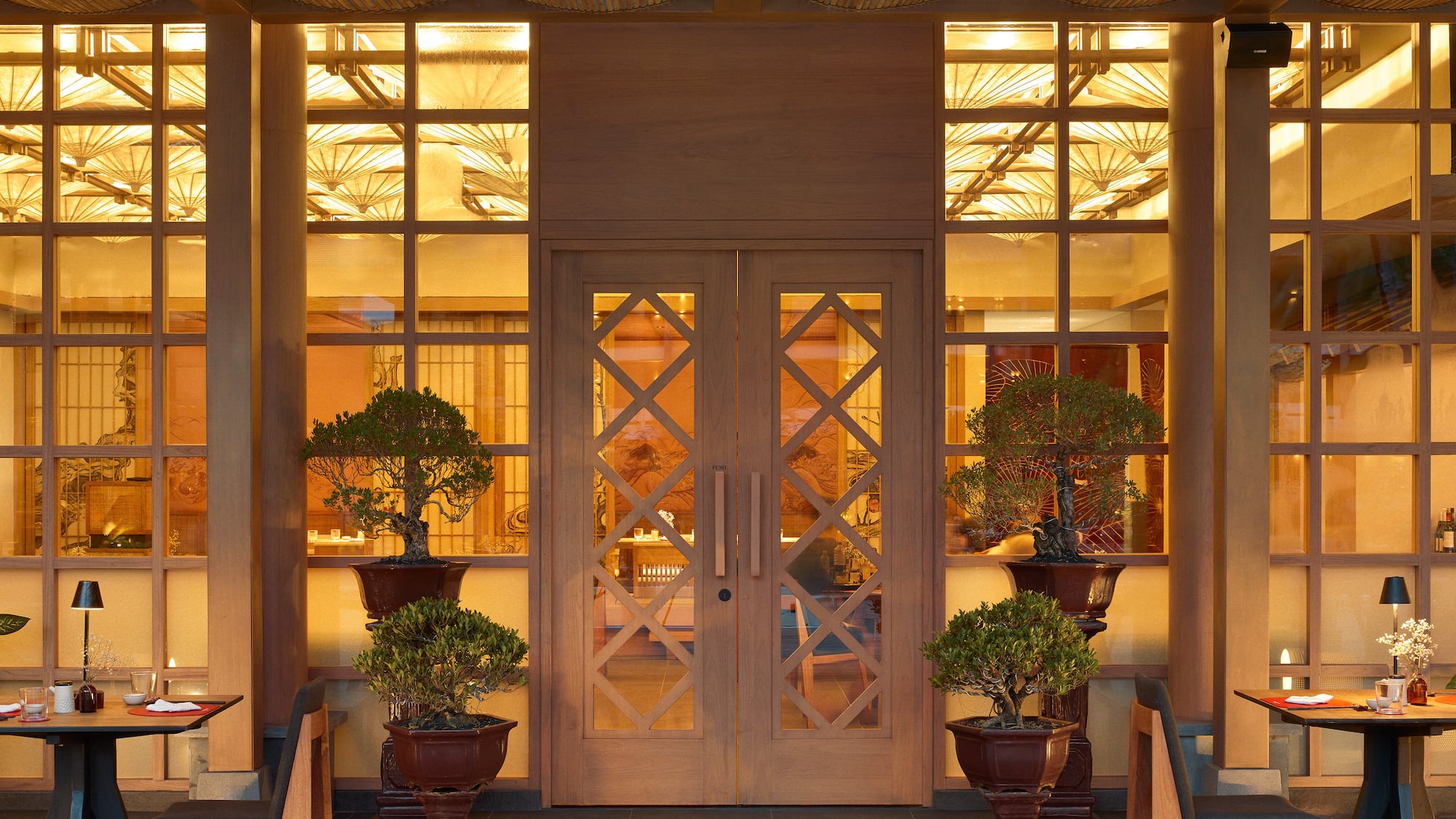 a front door of a building with a couple of potted trees