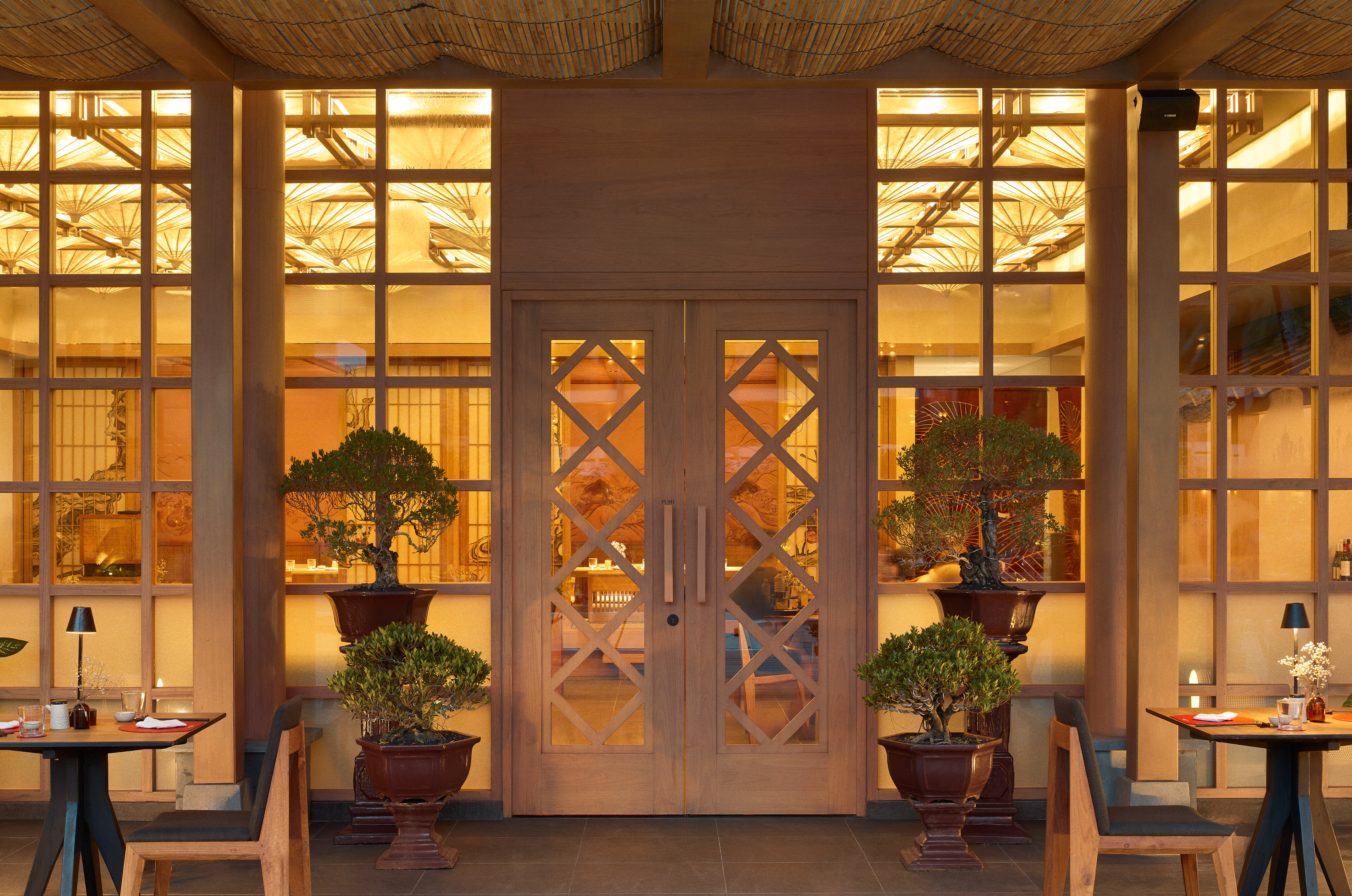 a front door of a building with a couple of potted trees