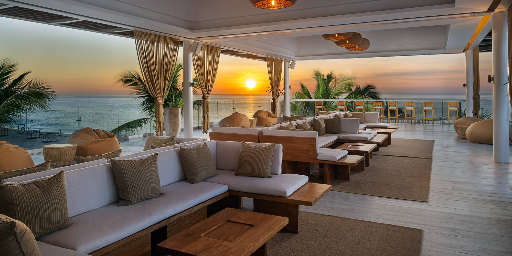 a room with couches and tables and chairs on the beach