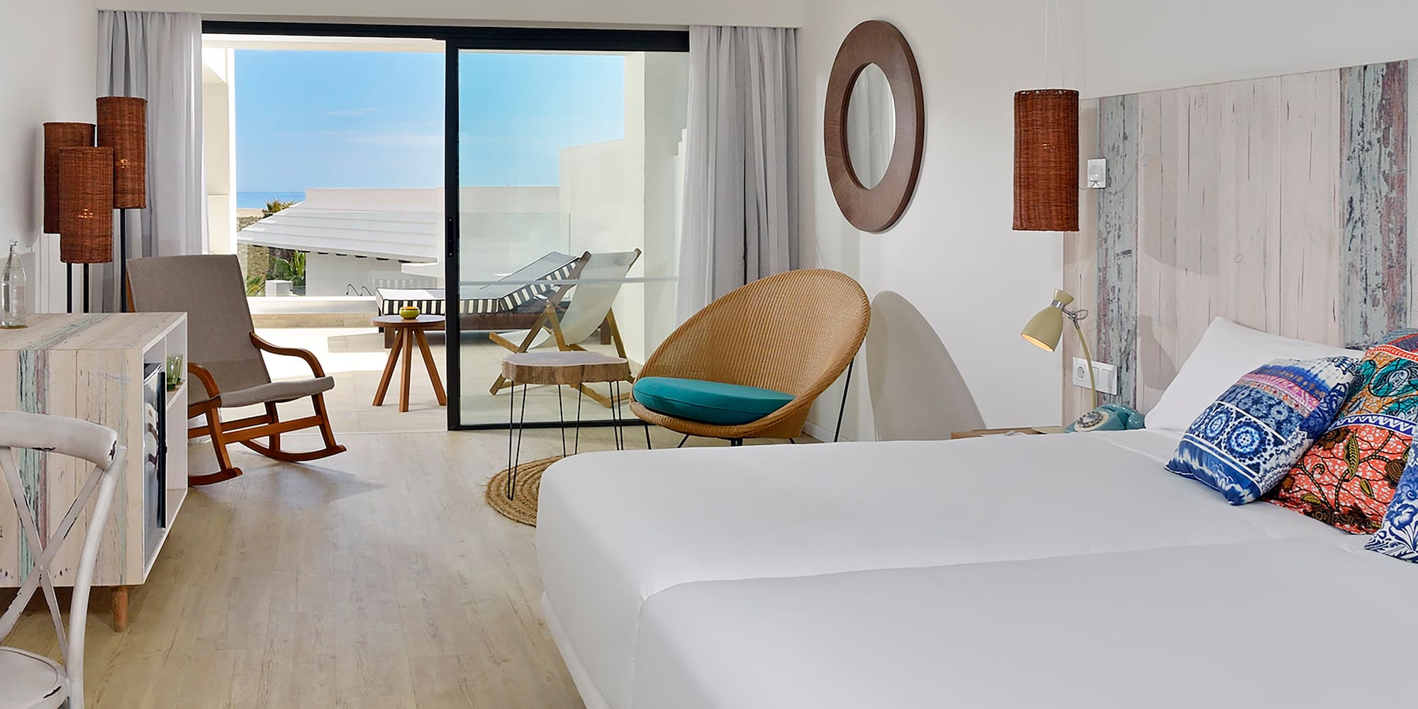 a room with a bed and chairs and a rocking chair