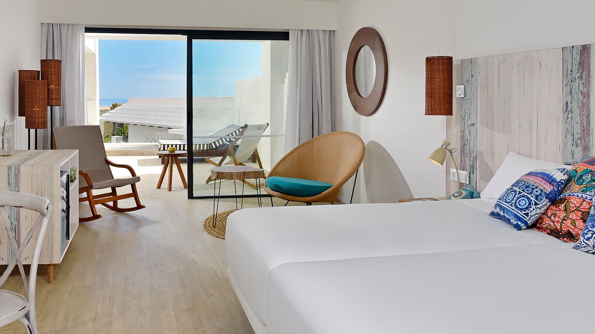 a room with a bed and chairs and a rocking chair