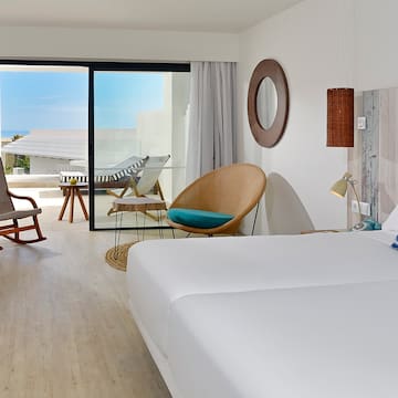 a room with a bed and chairs and a rocking chair