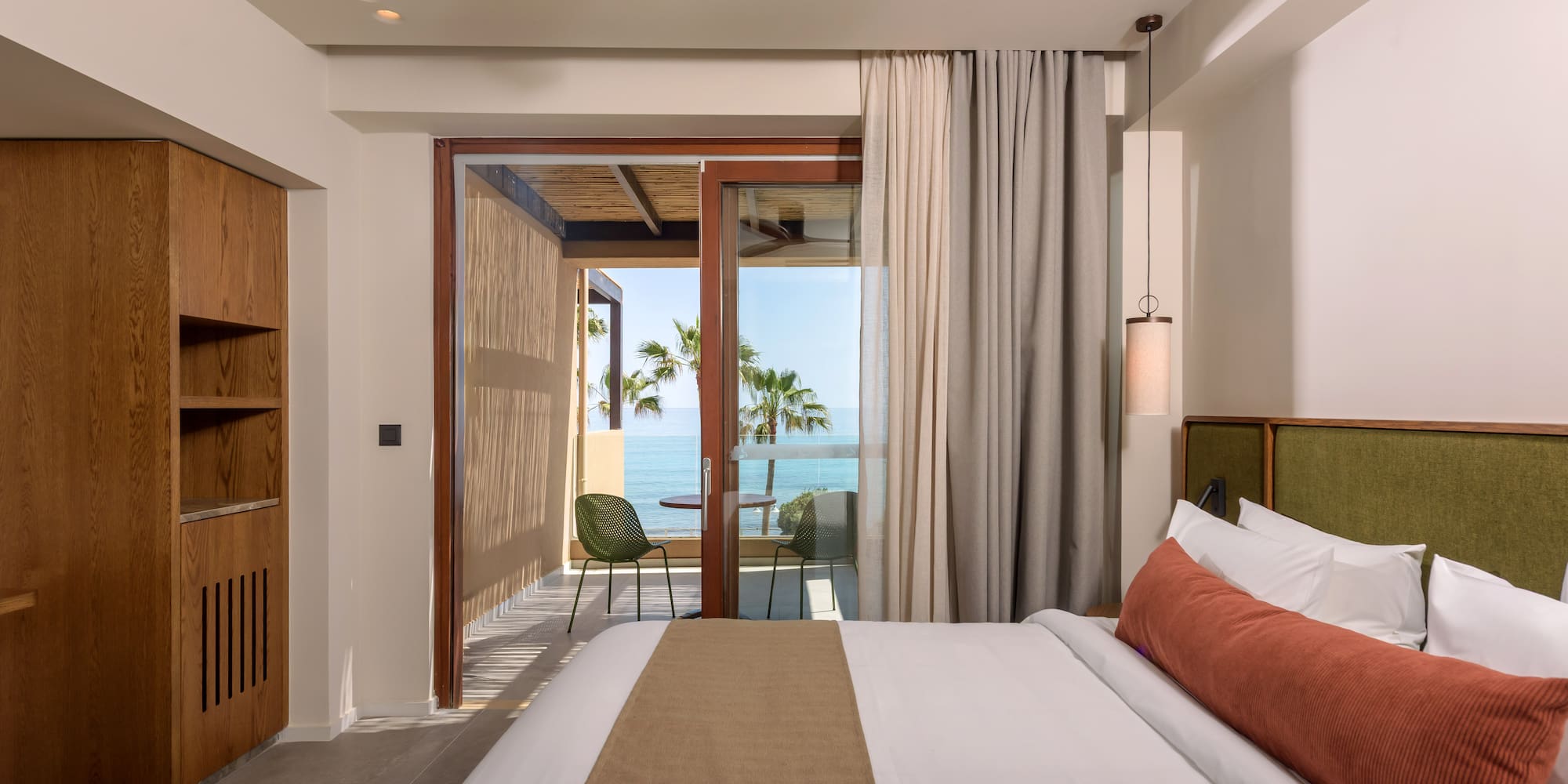 a bedroom with a glass door and a large bed.