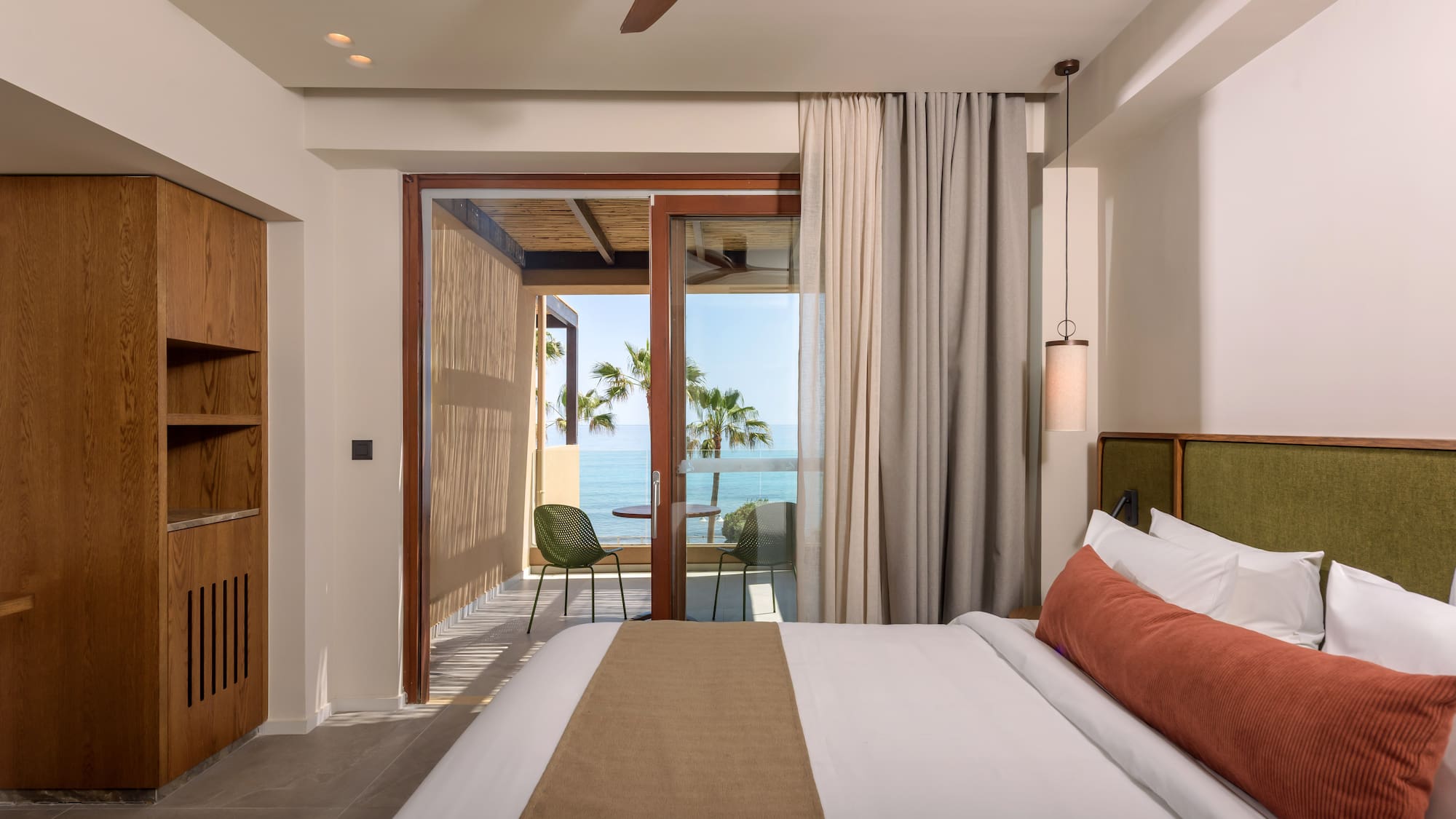 a bedroom with a glass door and a large bed.