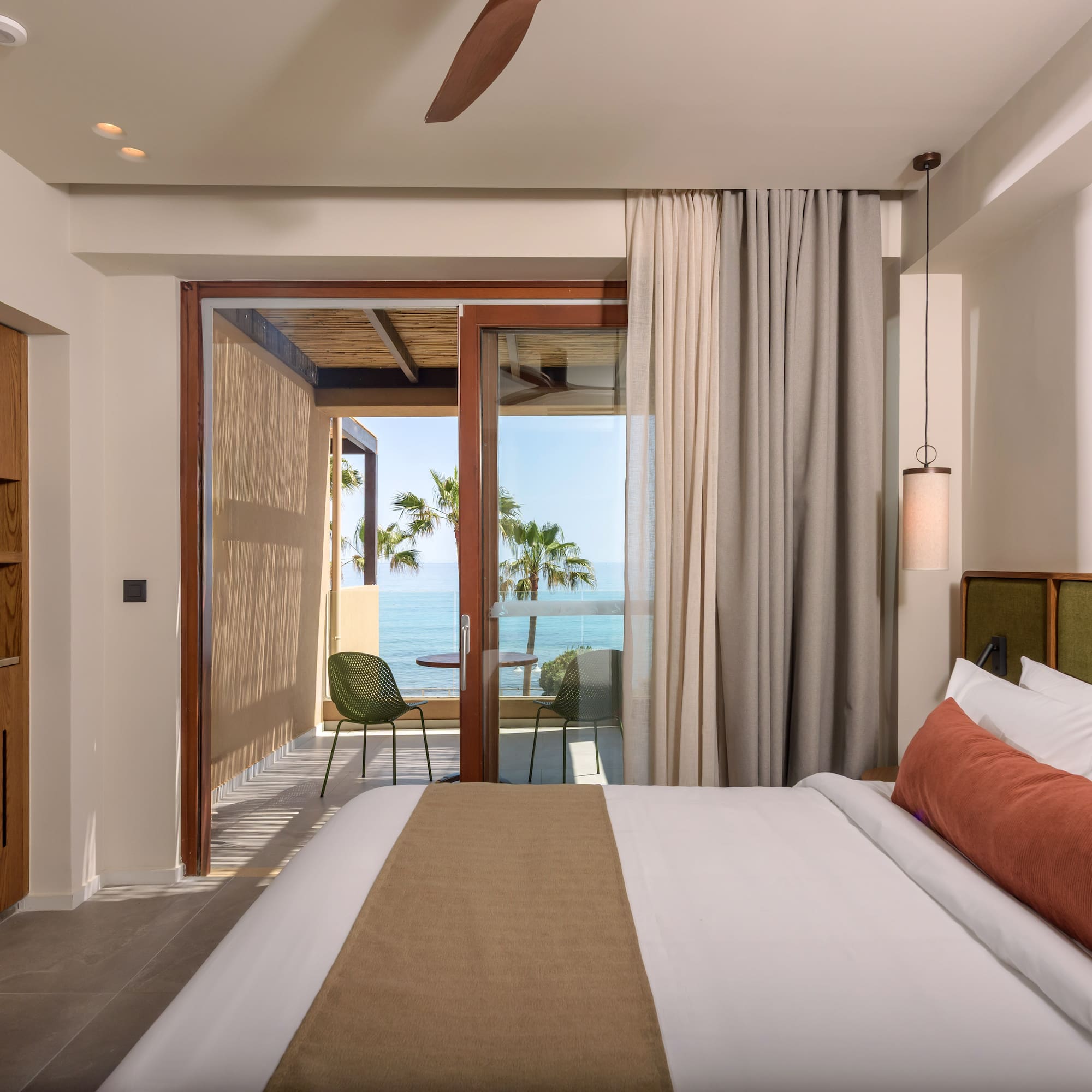 a bedroom with a glass door and a large bed.