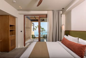 a bedroom with a glass door and a large bed.