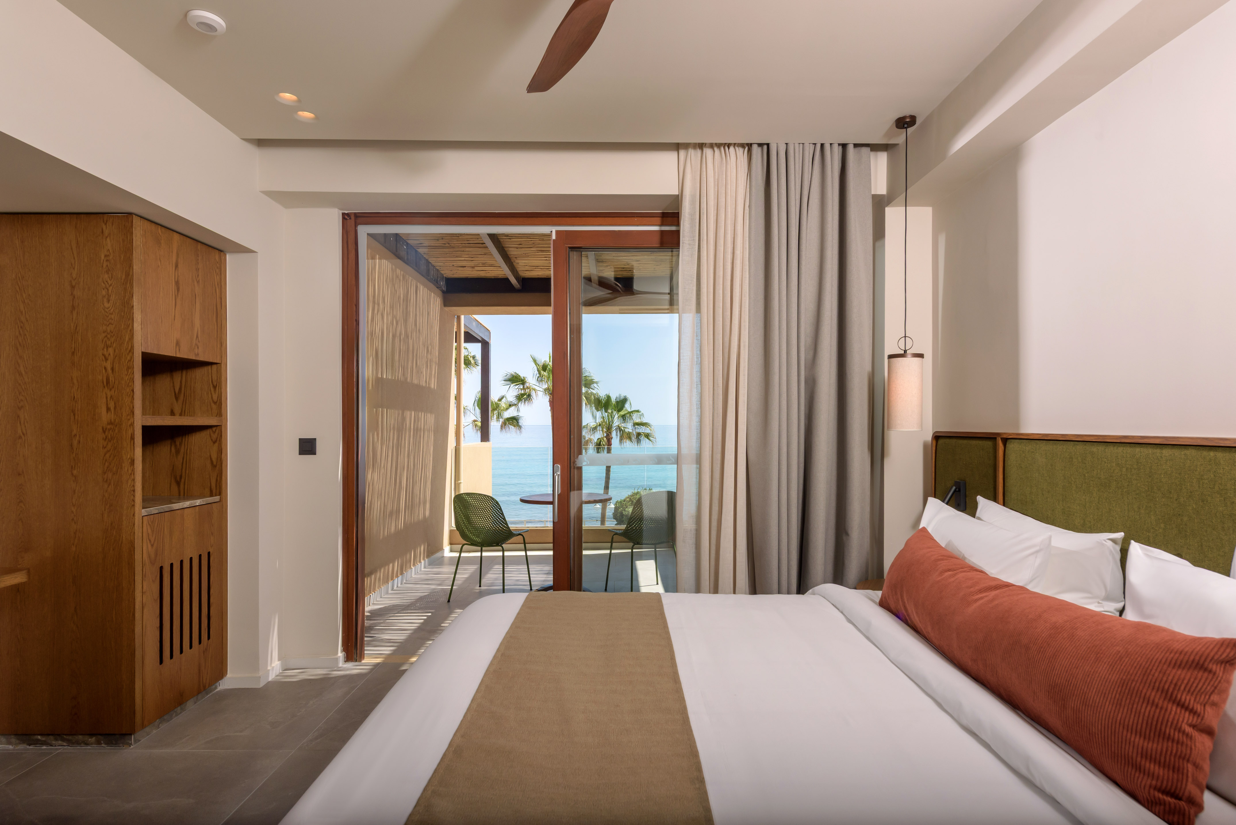 a bedroom with a glass door and a large bed.