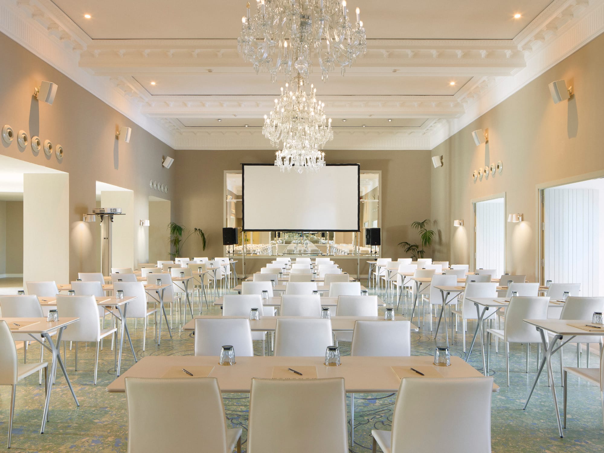 a room with tables and chairs and chandeliers