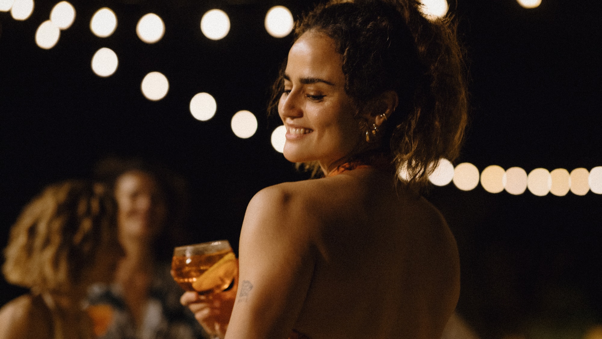 a woman smiling at a drink