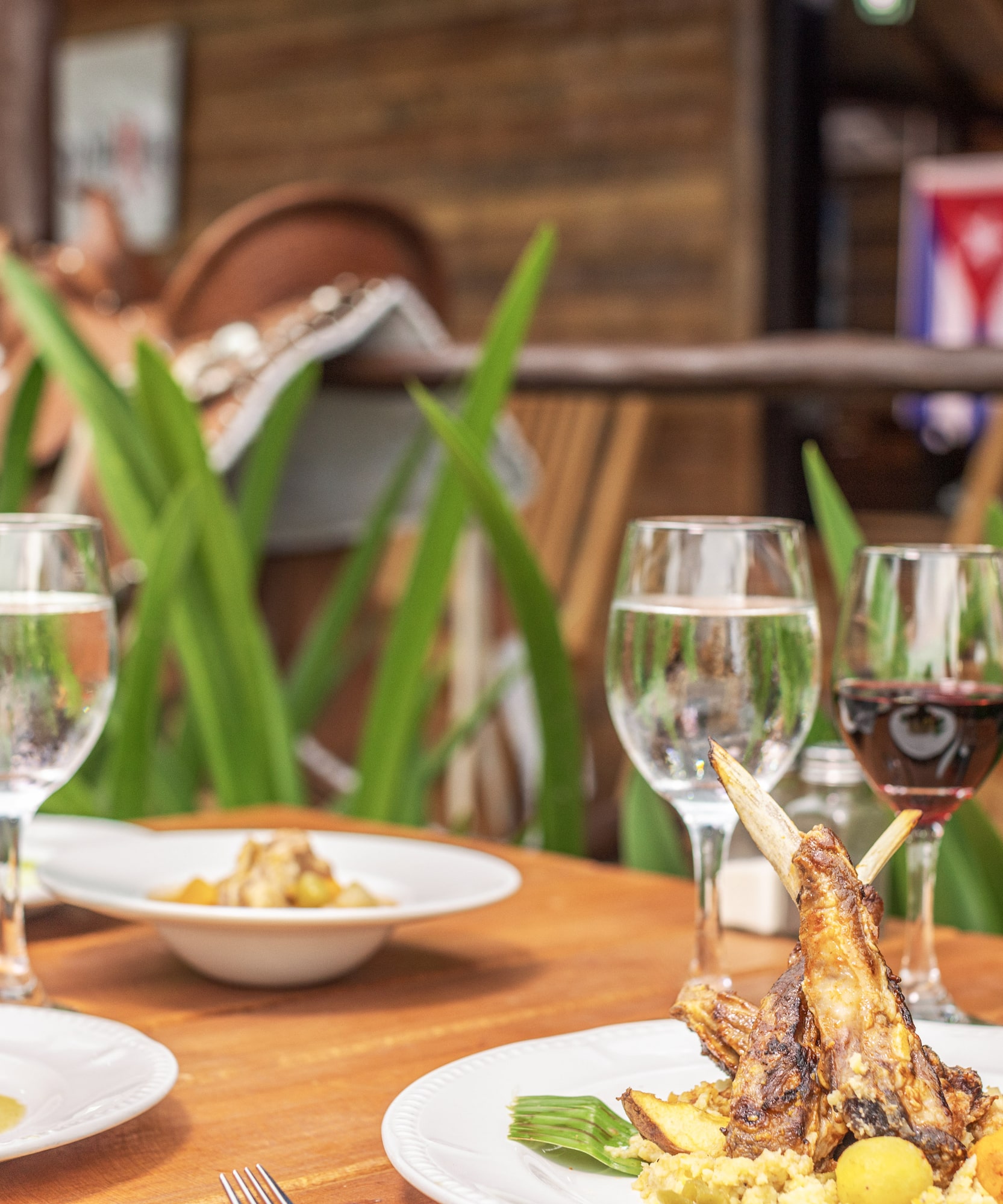 a table with plates of food and wine glasses