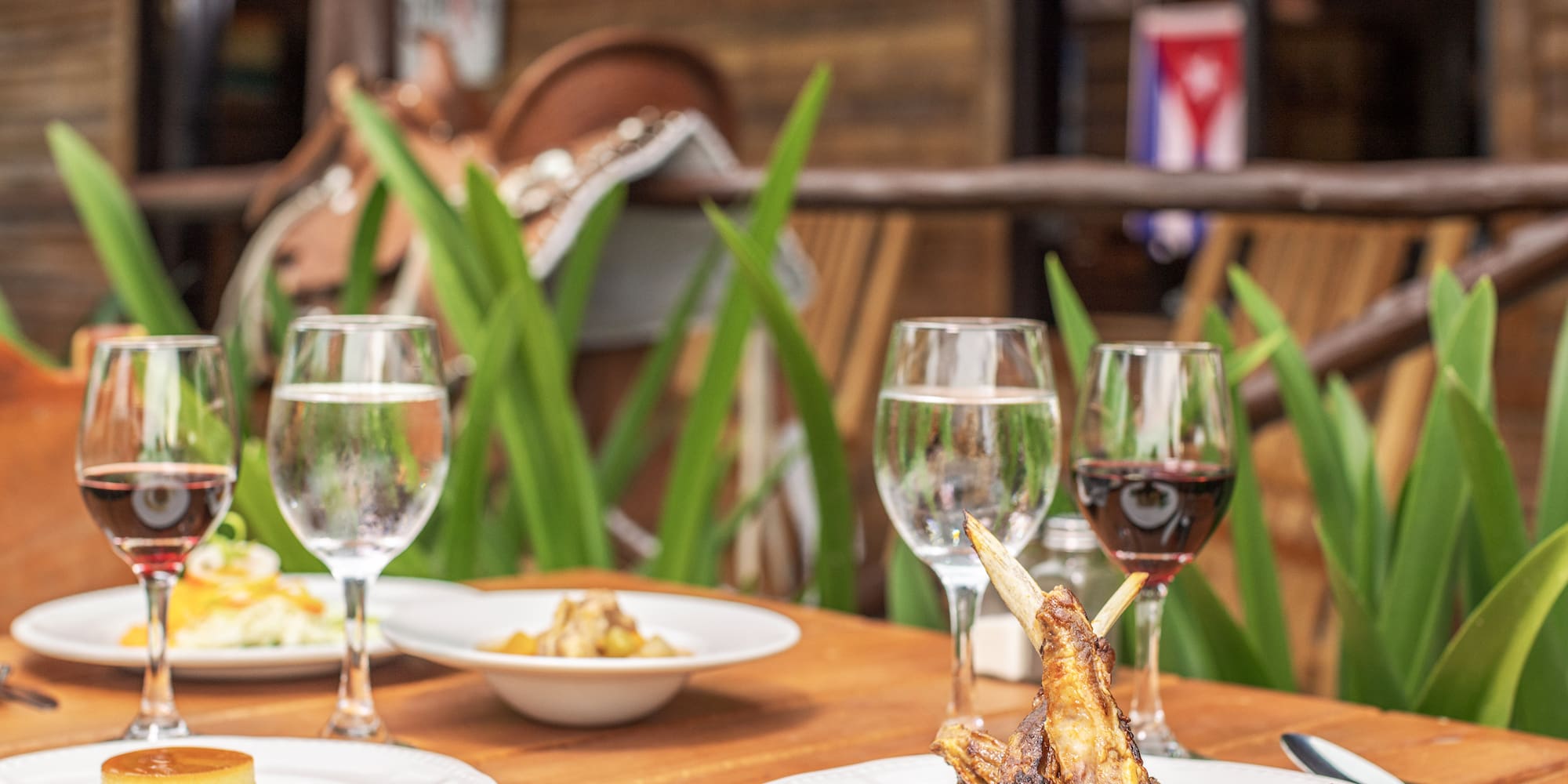 a table with plates of food and wine glasses
