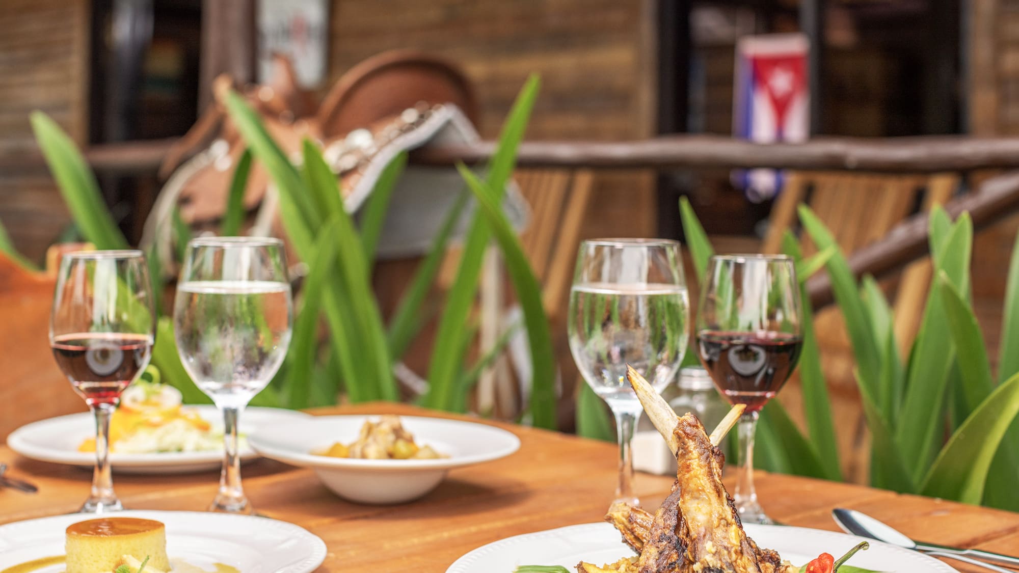 a table with plates of food and wine glasses