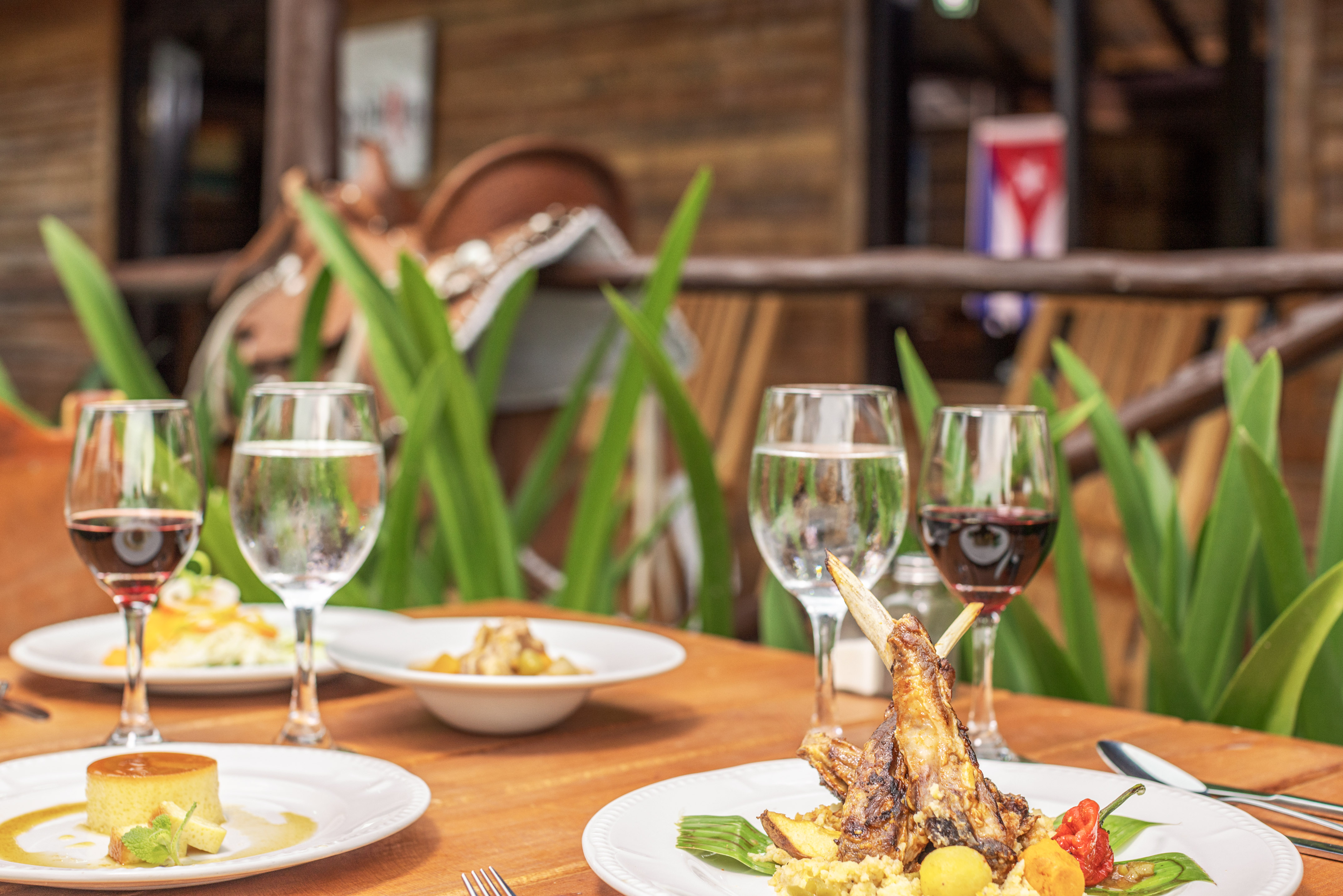 a table with plates of food and wine glasses