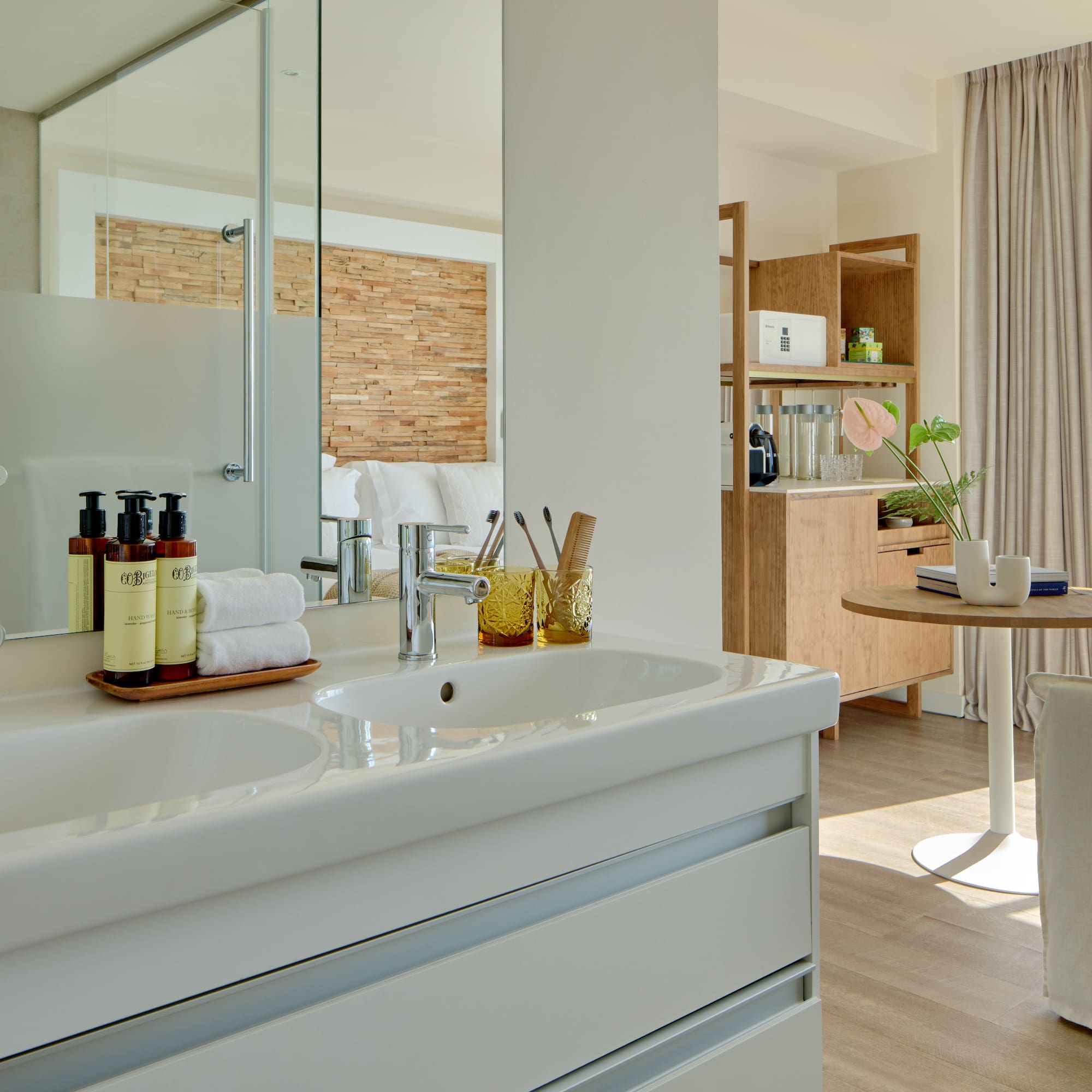 Modern hotel bathroom with double vanity overlooking a sea view suite.