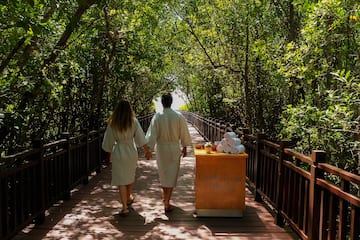 a man and woman walking on a bridge with a cart of towels