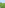 Green artificial turf soccer field with floodlights and ocean view.
