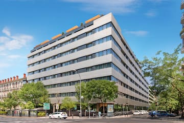 a building with trees and cars on the street