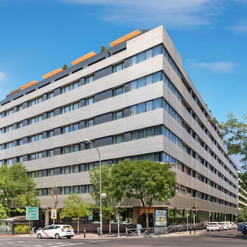 a building with trees and cars on the street