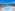 Luxury resort swimming pool with ocean view, palm trees, and sun loungers.
