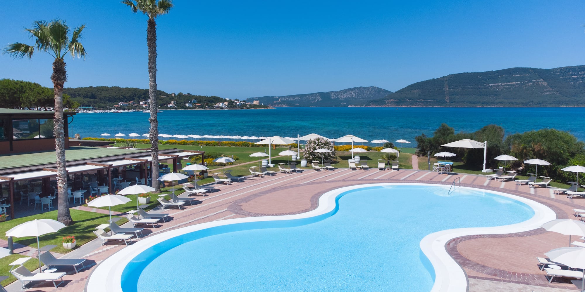 a pool with a beach and palm trees