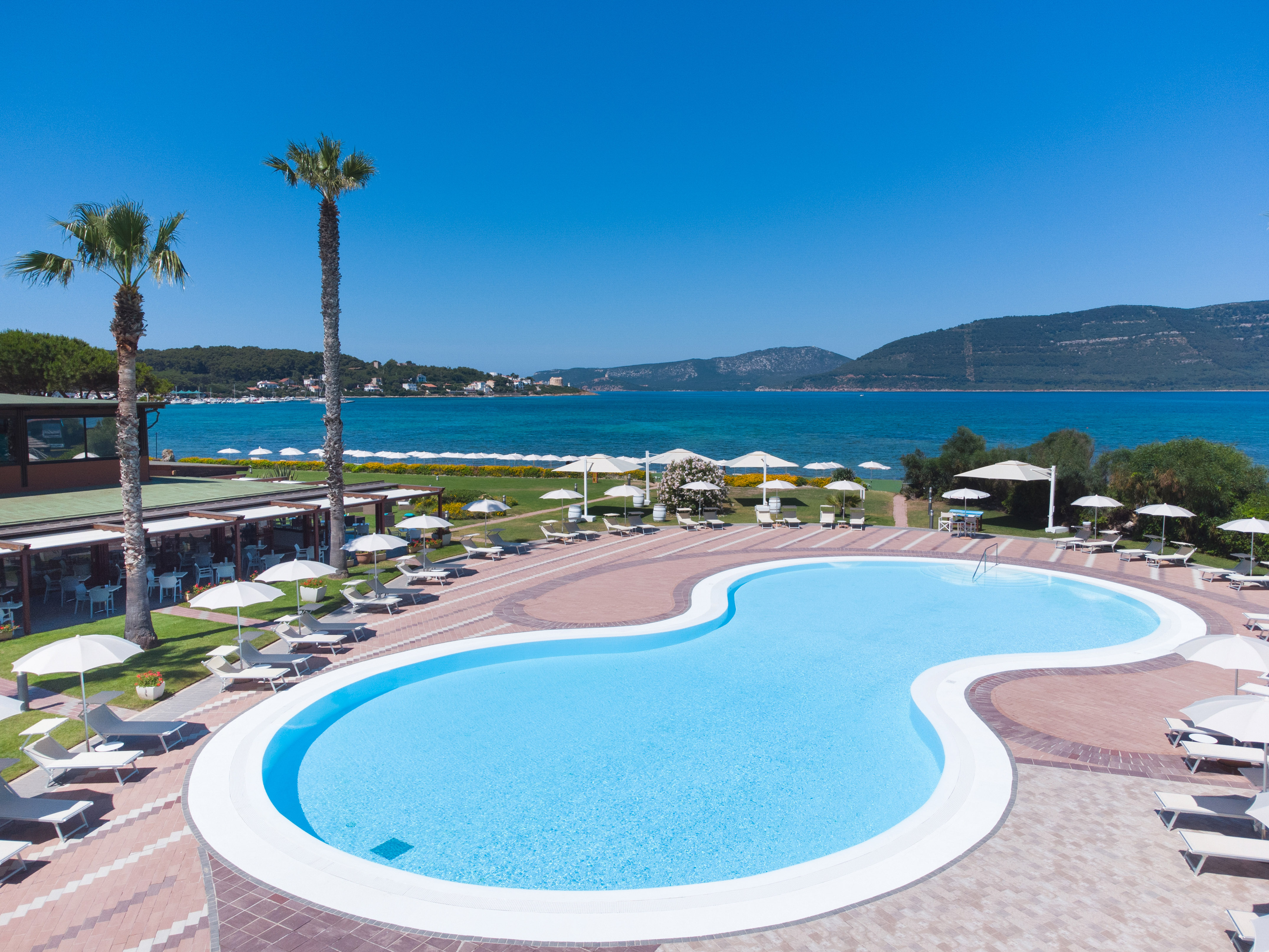 a pool with a beach and palm trees