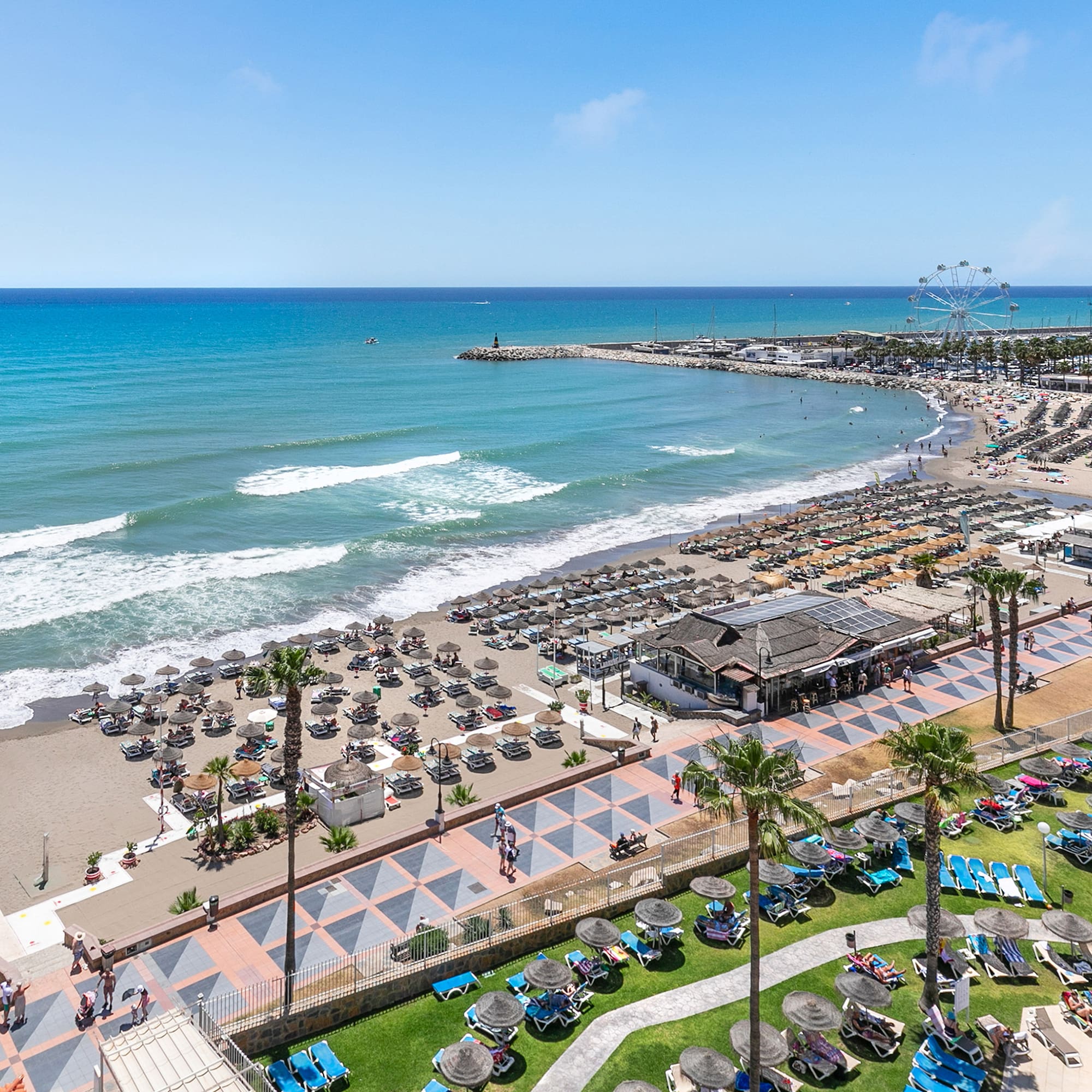 a beach with many chairs and umbrellas