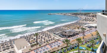 a beach with many chairs and umbrellas
